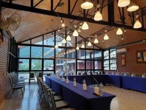 a large room with a long blue table and chairs at โรงแรมบีคูลบูทีค in Ban Hua Phrong