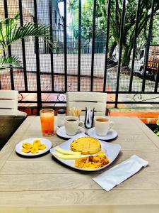 a table with two plates of breakfast food on it at Hotel pasarela real cali in Cali