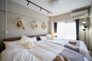 a bedroom with two beds with stuffed animals on them at Mezon Etowaaru in Nagoya