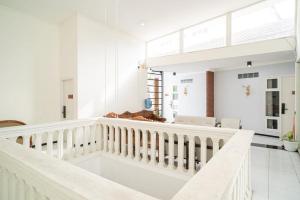 a white staircase in a white room with a stair case at RedDoorz Syariah At Mitra Guest House in Malang