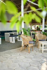 a group of chairs and tables in a patio at Hiricurry,Rooms Hostel & Restaurant in Dickwella