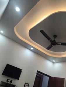 Un techo con un ventilador y un televisor en una habitación. en Hotel maya's, en Bāghpat