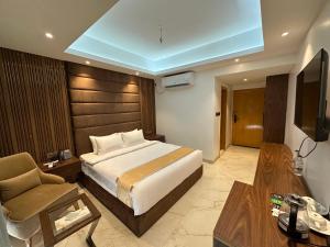 ein Schlafzimmer mit Bett, Sofa und Fernseher in der Unterkunft Hotel Makkah in Cox's Bazar