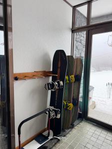 a group of snowboards are lined up against a wall at ゲストハウスルスティゲス in Kijimadaira