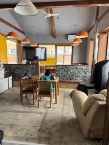 a living room with a table and a couch at ゲストハウスルスティゲス in Kijimadaira