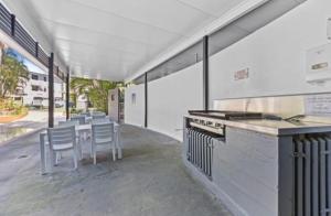 a kitchen with chairs and a table and a counter at Rainbow Beach Resort overlooking Pool in Rainbow Beach