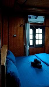 a bedroom with a blue bed with a window at Lanta Diamond in Ko Klang