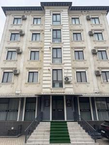 a large building with stairs in front of it at Best Guest House in Andizhan
