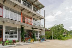 a building with tables and chairs outside of it at RedDoorz Plus @ Vantas Hotel Parbaba in Sinapuran