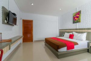 a bedroom with a bed and a television in it at RedDoorz Plus @ Vantas Hotel Parbaba in Sinapuran