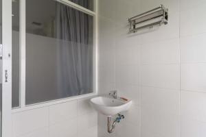 a white bathroom with a sink and a window at RedDoorz Plus @ Vantas Hotel Parbaba in Sinapuran +19 photos