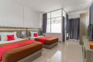 a hotel room with two beds and a television at RedDoorz Plus @ Vantas Hotel Parbaba in Sinapuran