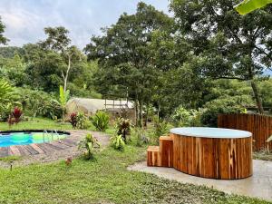 a garden with a wooden tub next to a pool at El Nido Andino in La Mesa