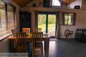 a dining room with a wooden table and chairs at Scotsdale Valley Studios in Harewood