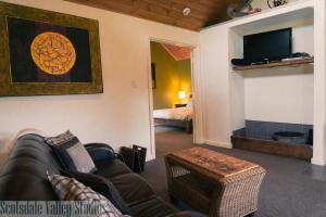 a living room with a couch and a tv at Scotsdale Valley Studios in Harewood