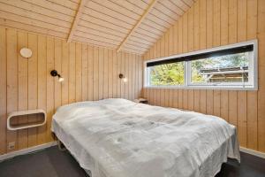 ein Schlafzimmer mit einem Bett in einem Zimmer mit Fenster in der Unterkunft SL353 Slagelse - Dompapvej 3 in Lille Kongsmark