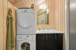 ein kleines Badezimmer mit Waschmaschine und Waschbecken in der Unterkunft SL353 Slagelse - Dompapvej 3 in Lille Kongsmark