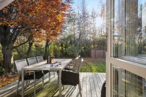 ein Tisch und Stühle auf einer Terrasse mit einem Fenster in der Unterkunft SL353 Slagelse - Dompapvej 3 in Lille Kongsmark