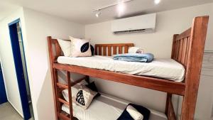 a bunk bed in a small room with at Suítes Santorini | The Férias - Aconchego no Centro de Arraial do Cabo com Cozinha Compartilhada e AR in Arraial do Cabo