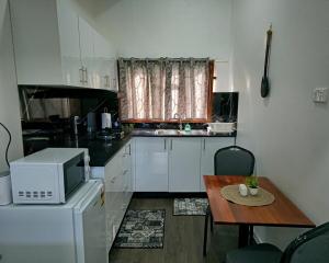 a small kitchen with a table and a microwave at Kula Nest in Suva
