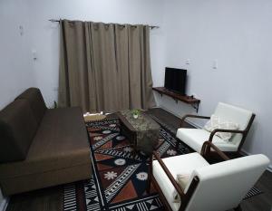 a living room with a couch and chairs and a television at Kula Nest in Suva