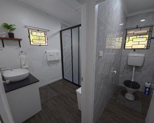a bathroom with a sink and a toilet at Kula Nest in Suva