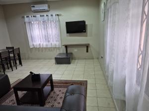 a living room with a couch and a television at Daysha's place in Tokuse