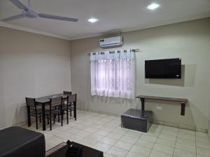 a living room with a television and a table and chairs at Daysha's place in Tokuse
