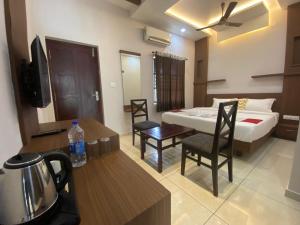 a hotel room with a bed and a table and chairs at Dreamland View Resort in Cochin
