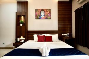 a hotel room with a bed with a white rabbit on it at Dreamland View Resort in Cochin +25 photos