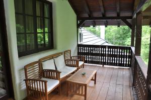 a porch with two chairs and a table and windows at Cabana Izvoranu in Izvoranu