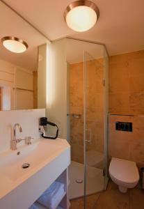 ein Bad mit einer Dusche, einem Waschbecken und einem WC in der Unterkunft Gästehaus Schloss Bernau in Fischlham