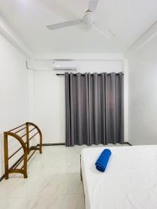 a bedroom with a bed with a blue pillow on it at SH Villa in Weligama