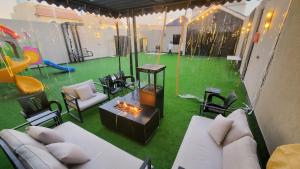a living room with a fire pit and a playground at اندلس فيو in Riyadh