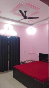 a room with a bed with a ceiling fan at Laxminarayan Sadan in Ayodhya +4 photos