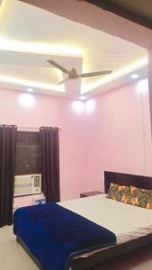 a bedroom with a bed with a ceiling fan at Laxminarayan Sadan in Ayodhya