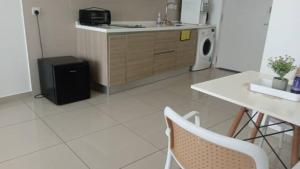 a kitchen with a refrigerator and a table and chairs at Tasneem Guesthouse in Shah Alam