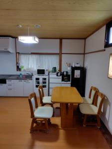 a kitchen with a table and chairs in a room at コテージマリンハウス ---8月末まで断水中--- in Kami Amakusa