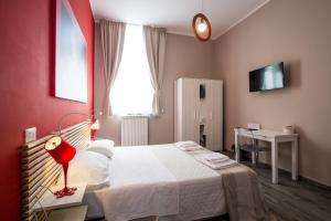 1 dormitorio con cama blanca y pared roja en Le Cupole Design, en Palermo