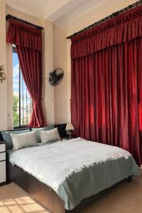 a bedroom with a large bed with red curtains at Perfume Homestay Huế in Hue