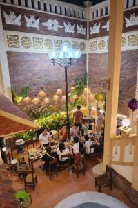 a group of people sitting at tables in a restaurant at Perfume Homestay Huế in Hue