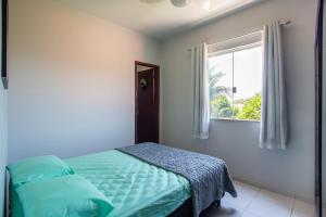 a bedroom with a bed and a window at Casa de Vila Duplex, perto do Centro in Araruama