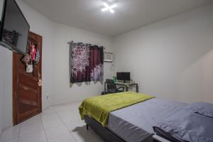 a bedroom with a bed with a green blanket on it at Casa de Vila Duplex, perto do Centro in Araruama