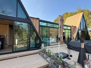 a house with glass windows on a wooden deck at Moyard Khaoyai in Ban Khanong Phra Klang (1)
