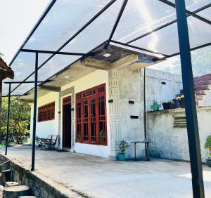 a glass pavilion in front of a building at Ohiya Alpine River Lodge in Ohiya