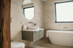 a bathroom with a sink and a tub and a toilet at 3 Acres by the Moyne in Port Fairy +23 photos