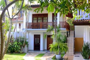 a house with a staircase and a balcony at Surf Villa Hikkaduwa in Hikkaduwa