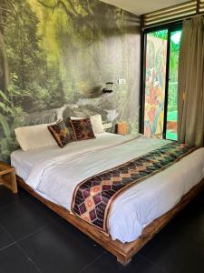 a bedroom with a bed with a painting on the wall at Hillora Coastal Resort in Arpora