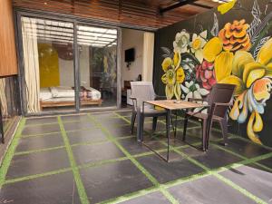 a room with a table and chairs and a mural at Hillora Coastal Resort in Arpora