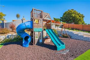 a playground with a blue slide and a house at Panoramic view in San Marcos